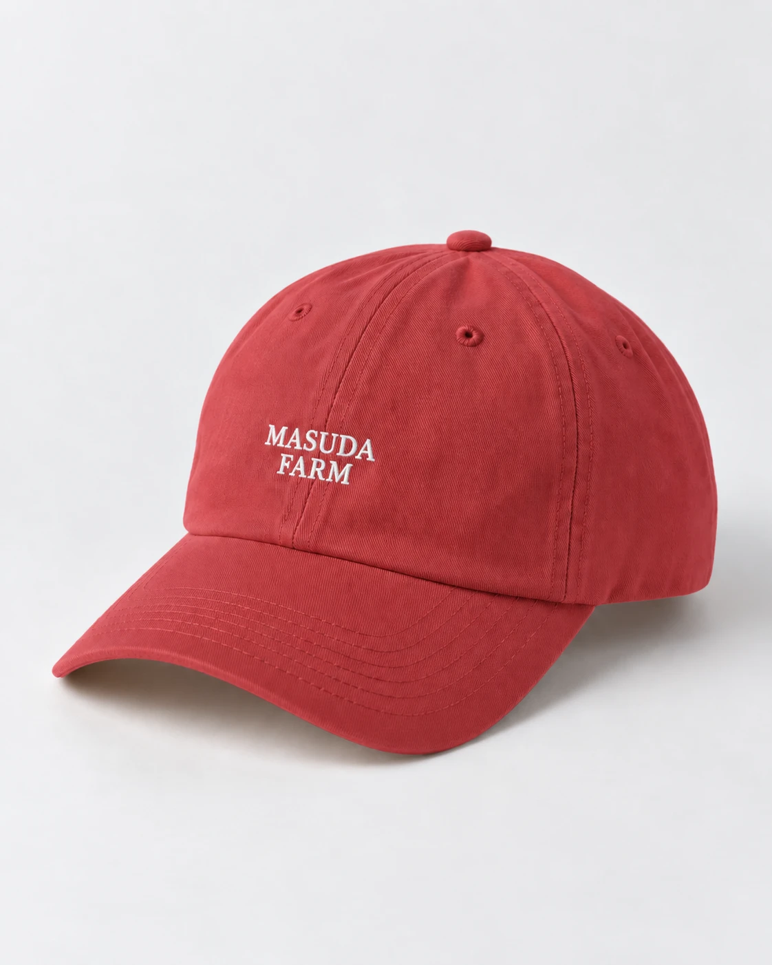 白でMASUDA FARMと刺繍された赤いキャップ。